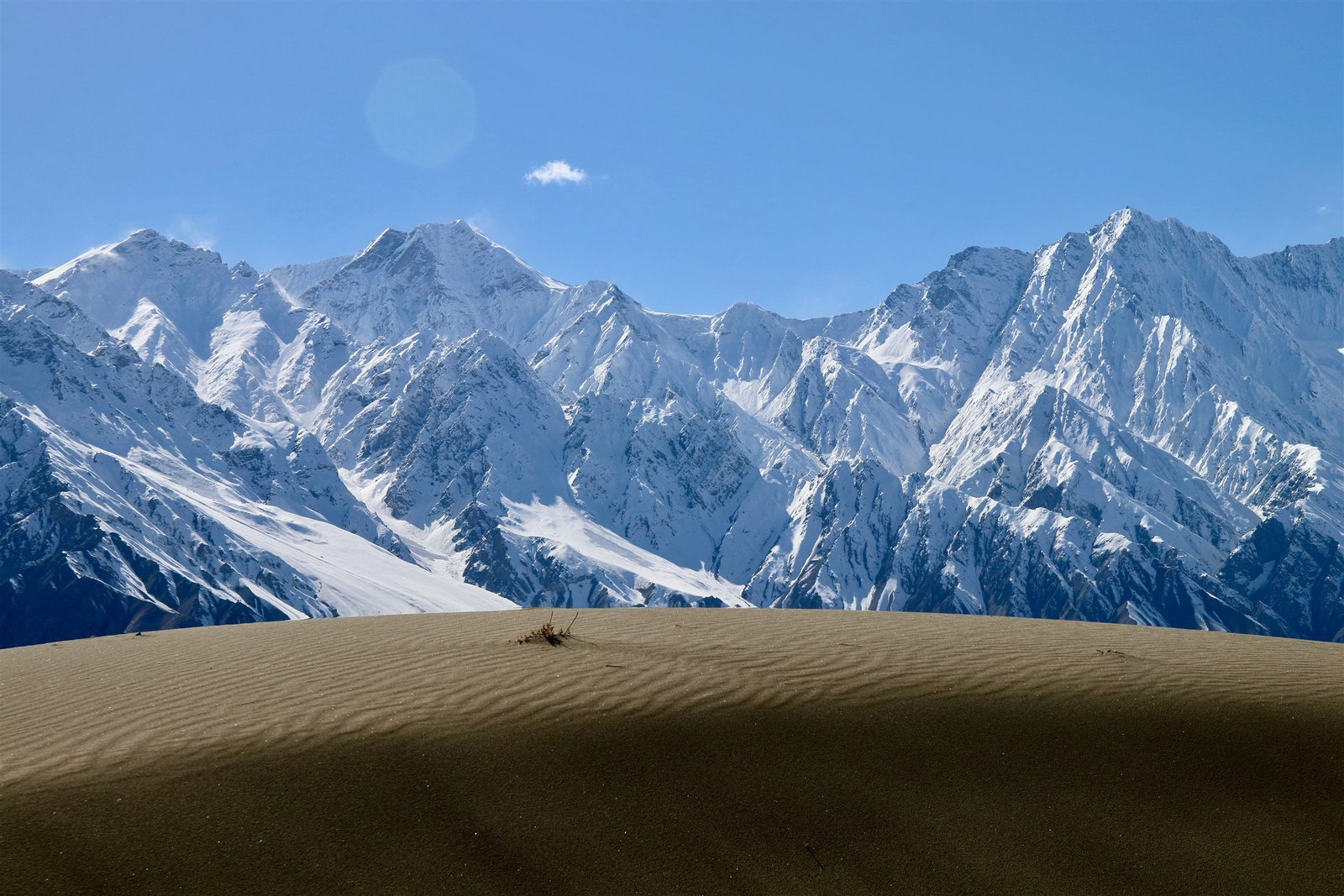 Rippled sand dunes of the Skardu cold desert beneath a wall of snow peaks
